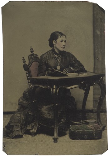 Seated woman at table, wearing gloves