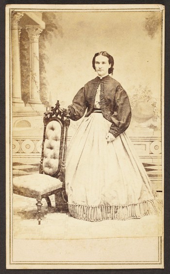 Unknown sitter [portrait of a standing woman holding on to an upholstered chair]