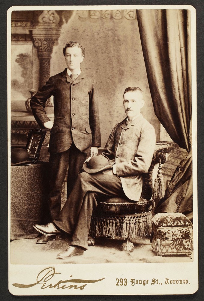 Unknown sitters [portrait of standing man and a seated man with hat on lap]